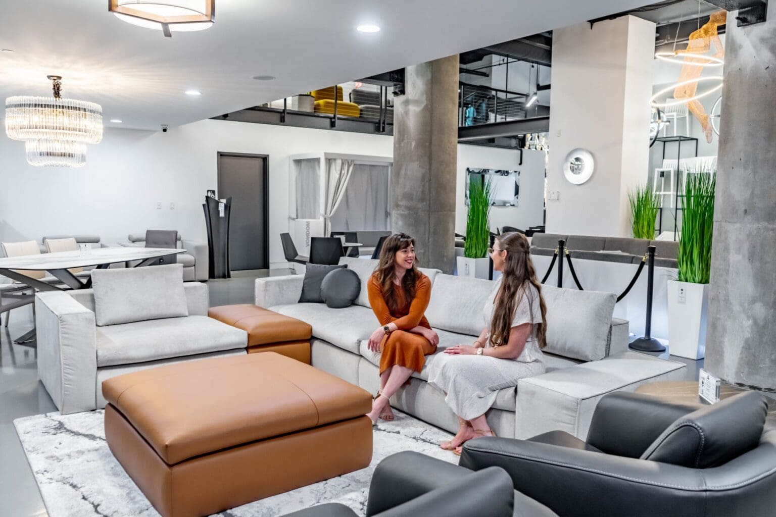 Two women talking in a modern office lounge.